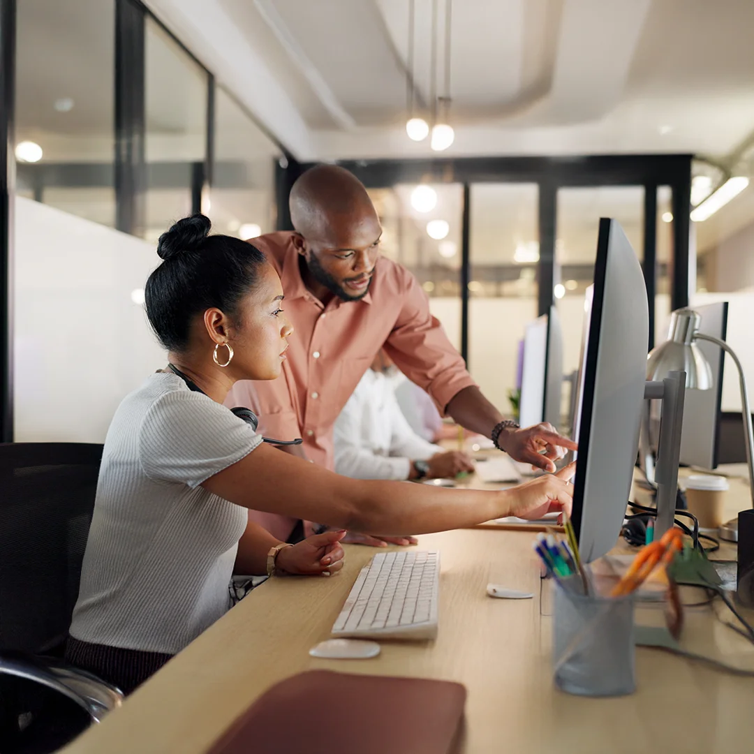 Colleagues Collaborating At A Shared Workstation
