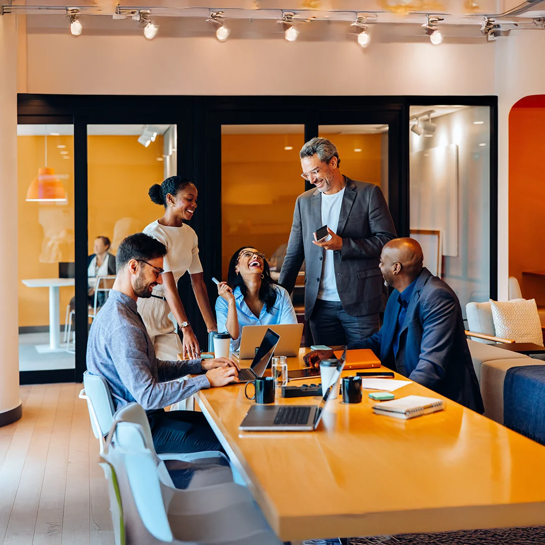 Team Collaboration And Laughter In A Modern Office Meeting