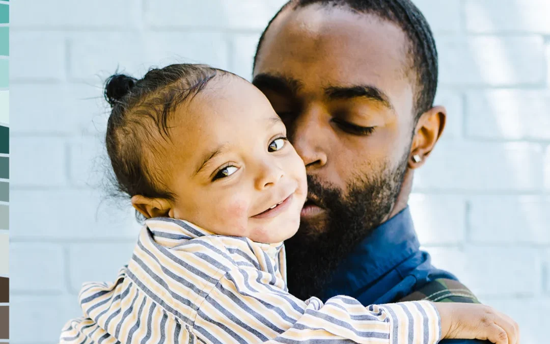 Adult holding and embracing a young child in a caring and supportive home setting
