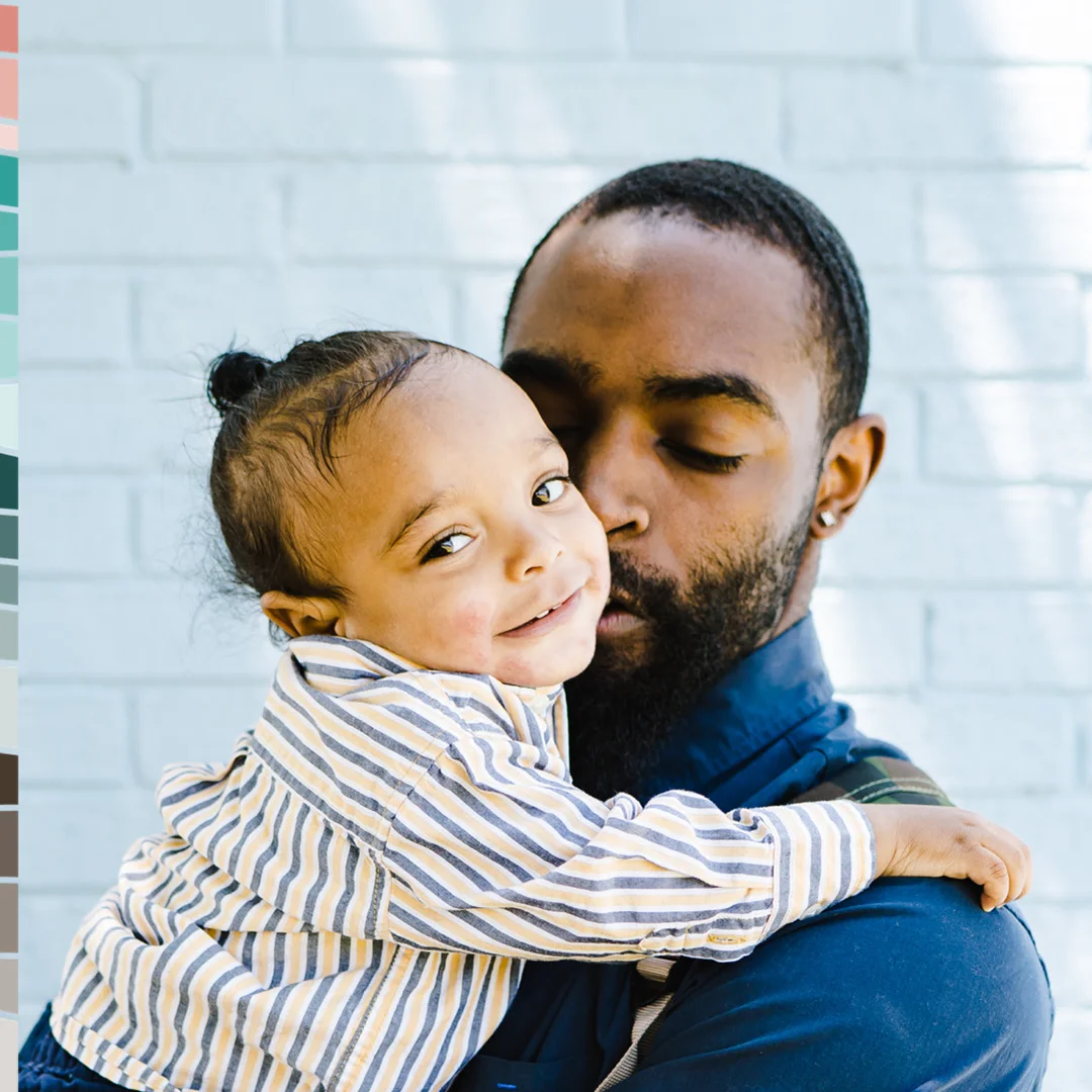 Adult holding and embracing a young child in a caring and supportive home setting